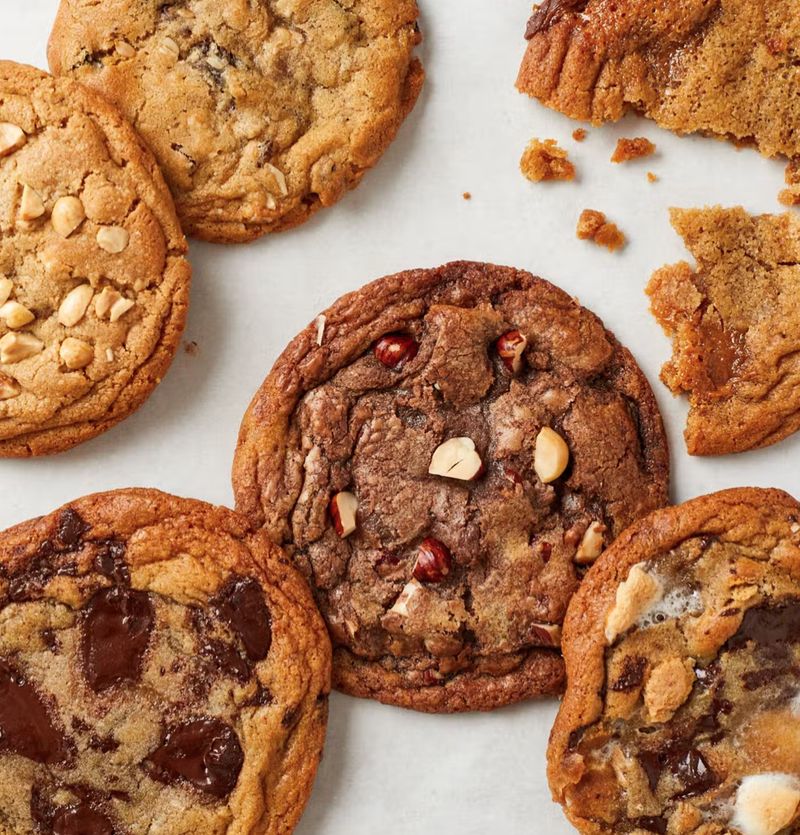 An assortment of cookies on parchment — chocolate chip, peanut and oat